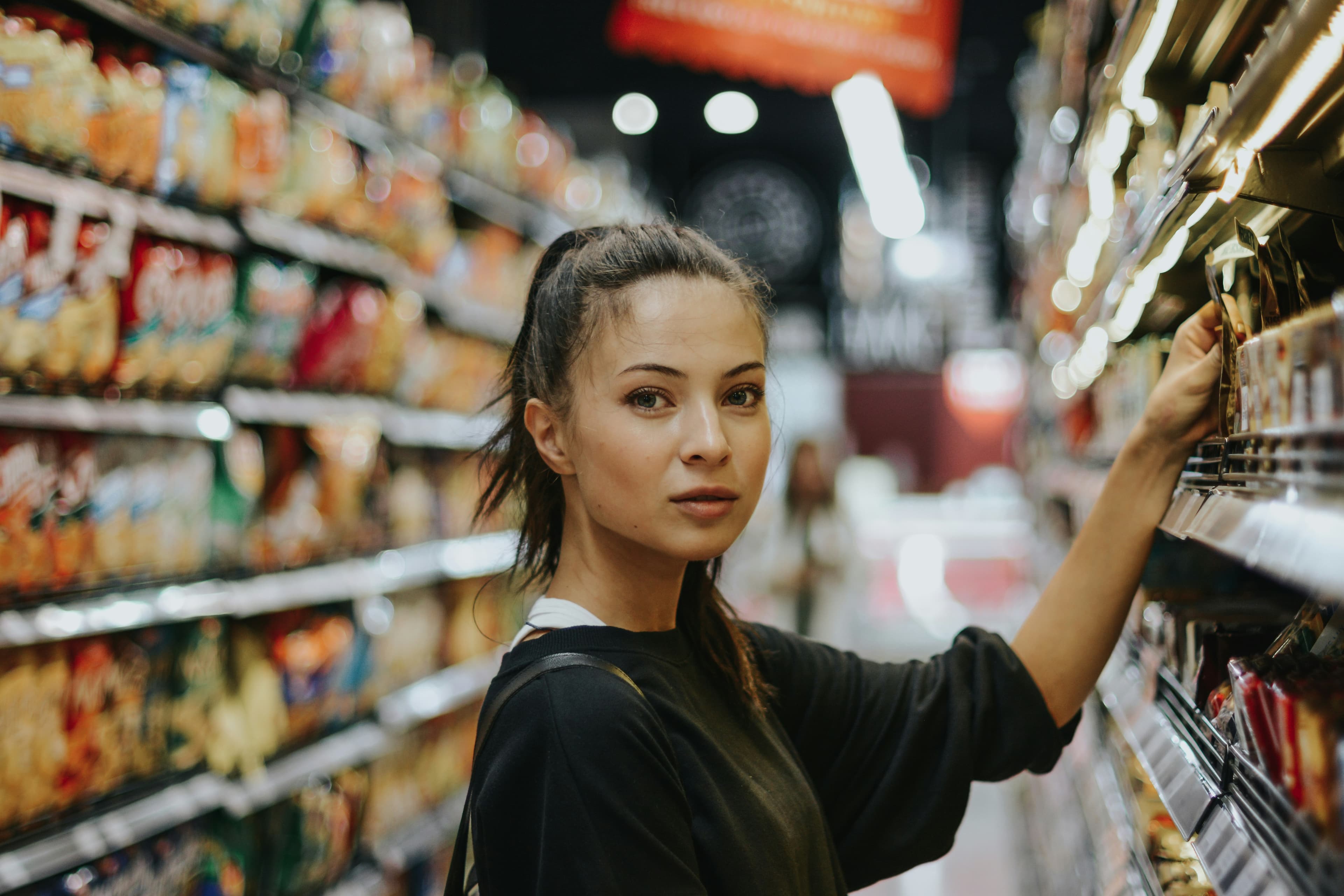 A shopper selecting a product from a retail shelf